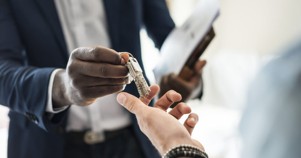 agent immobilier tendant des clés à un client